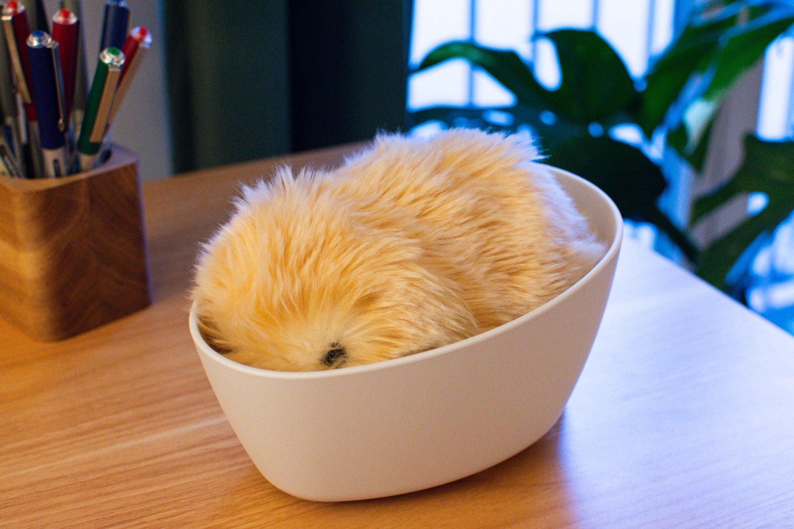 Moflin in its charging pod slash bed.