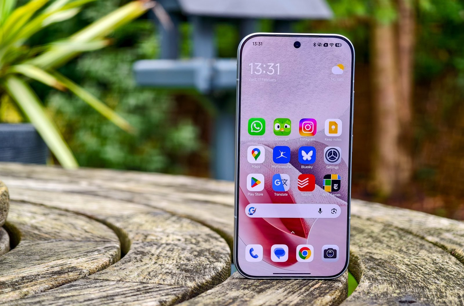 Photo of Xiaomi 17 homescreen on a wooden table outdoors