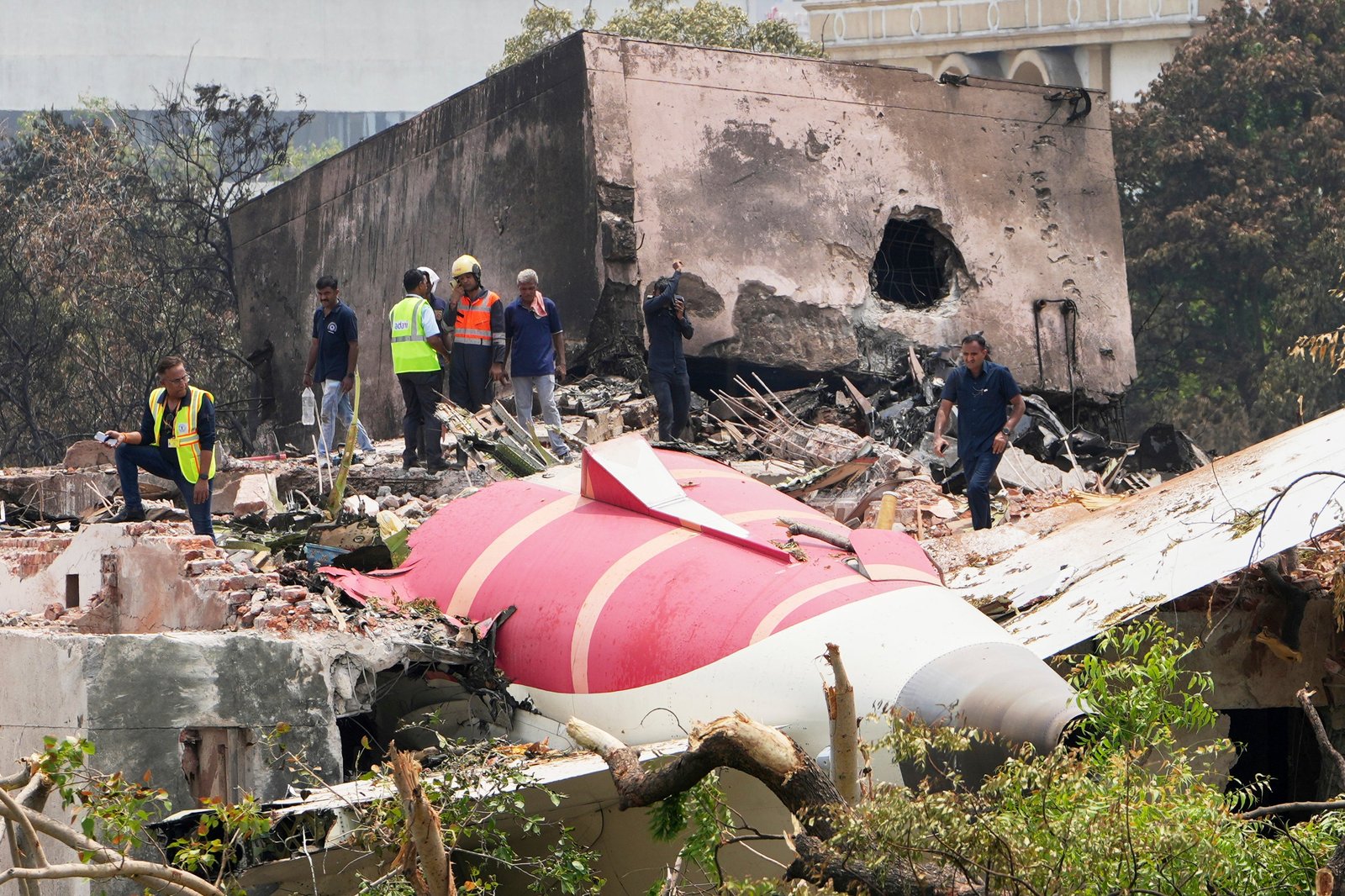 Officials inspect the site of Air India plane crash on the roof of a building in Ahmedabad, India.