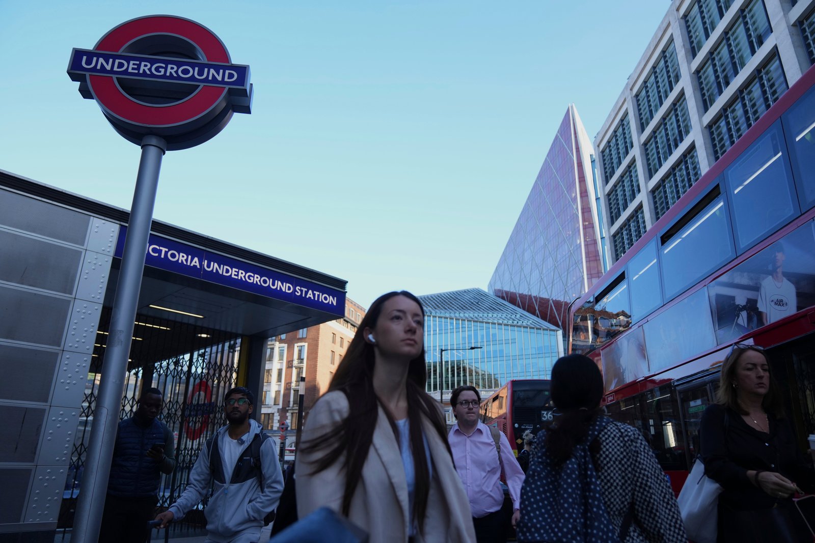Commuters pass by the closed entrance of Victoria Underground station during a strike in 2025