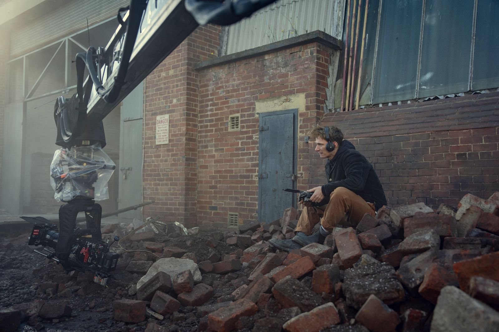 Image may contain Tom Harper Person Teen Electronics Headphones Taking Cover Gun and Weapon