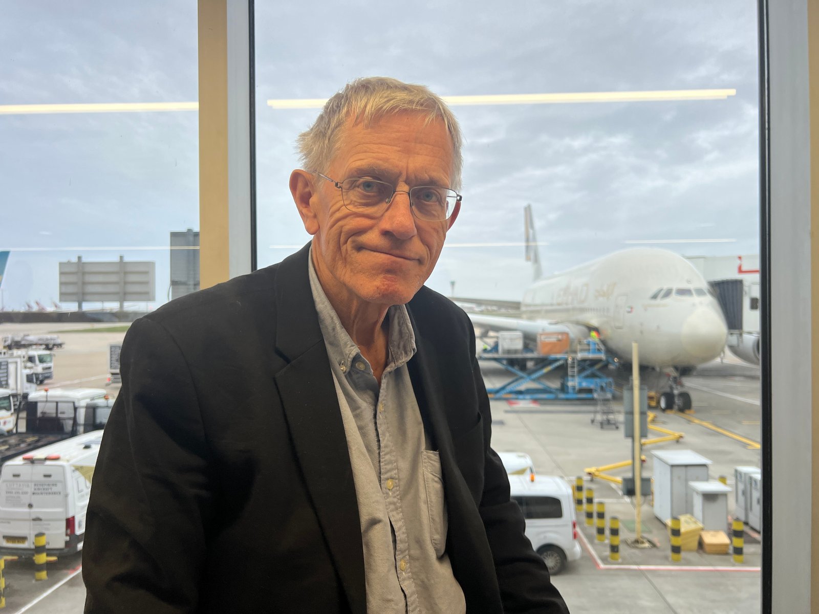 Now, where's that tea? Simon Calder on arrival at London Heathrow, with the Etihad jet in the background