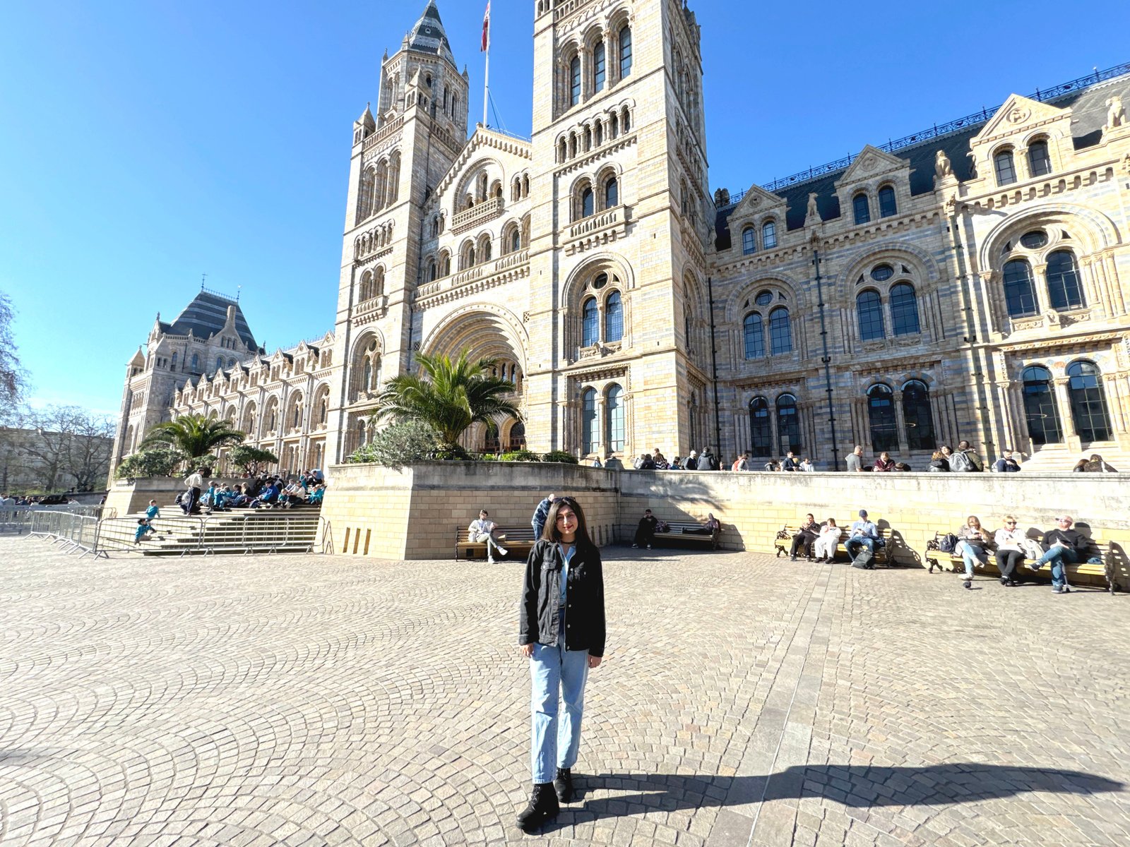 Queenie visiting the Natural History Museum on a blue-sky day