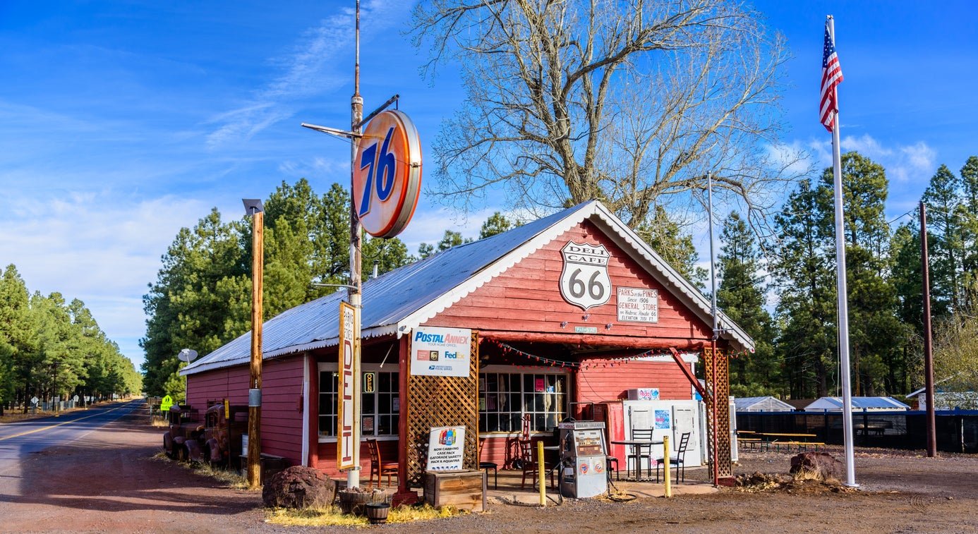 The Parks in the Pines General Store and Deli stands along a quiet stretch of Route 66 between Williams and Flagstaff, its vintage 76 sign and weathered red storefront preserving the classic character of mid-century roadside travel in Northern Arizona