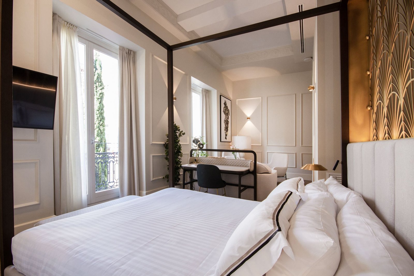 Some rooms feature four-poster beds with decorative fan-motif metal screens