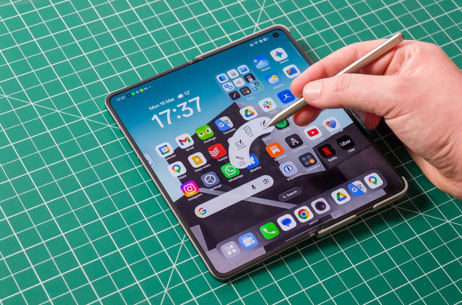 Photo of Oppo Find N6 on a green work mat from above, showing the AI Pen stylus controls